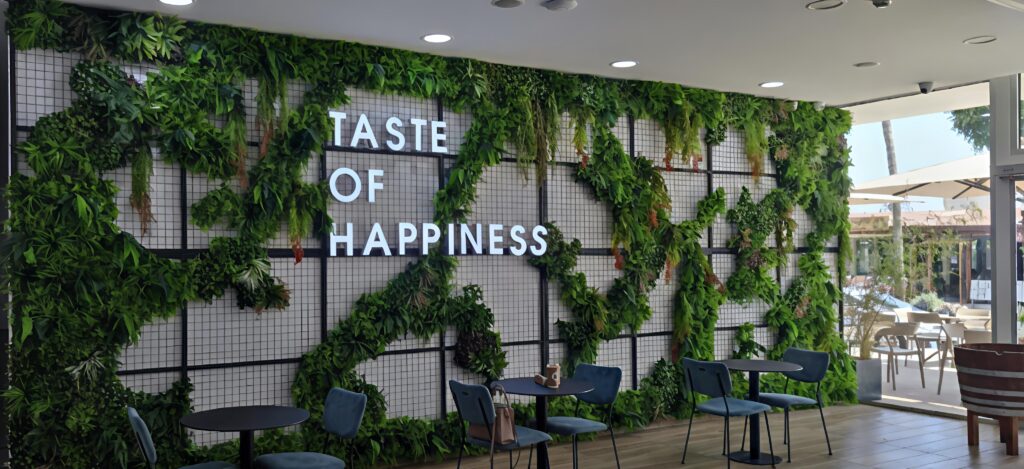 Finalized artificial vertical garden installation at Alpha Mega Stadium in Limassol, featuring lush greenery on columns, windows, and walls for a modern and inviting stadium interior.